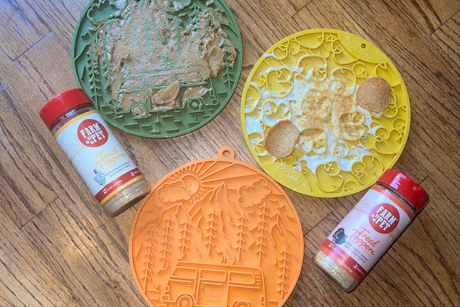 three lick mats in different designs with Farm to Pet dog food toppers